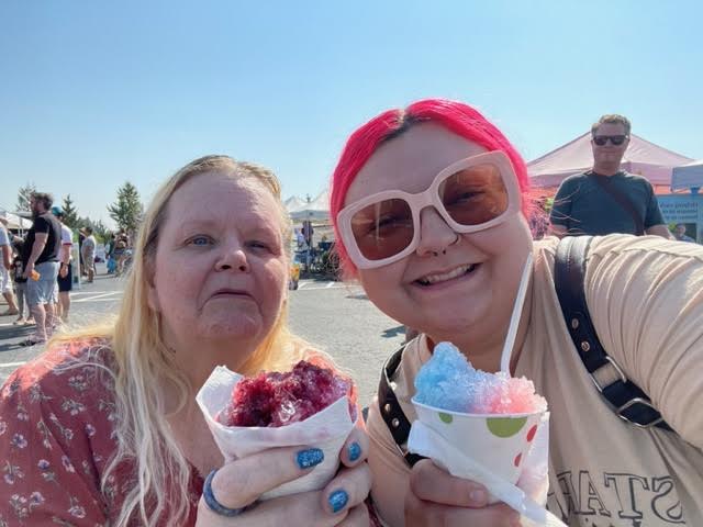 senior woman and activity director enjoying a snow cone in the sunshine